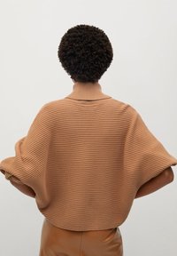 Brown ribbed knit sweater with a mock collar, relaxed fit, and wide sleeves. The texture appears soft, providing a cozy look.