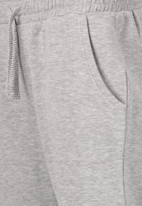 Grå sweatshirtbyxor med en mjuk textur, elastisk midja med extern justerbar snörning och sidofickor.