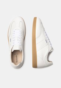 Hvide lædersneakers med en tekstureret overflade, der har en gummisål, hvide snørebånd og syede detaljer på siderne.