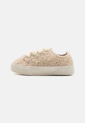 Beige textuursneaker met een fluweelachtige bovenkant, beige veters en een rubberen zool met een patroon voor grip. Zijaanzicht.