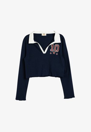 Marineblauer kurzer Pullover mit einem weißen Kragen. Mit einer roten "10" und zwei Sternen auf der linken Brustseite. Gerippte Textur.