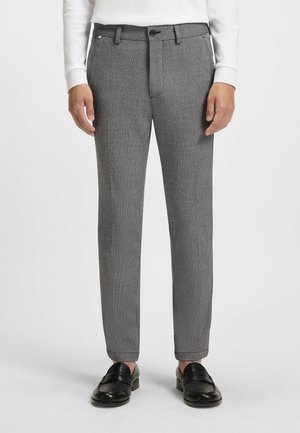 Gray textured trousers with a straight cut, featuring front pockets, a zip fly with a button closure, and cuffs. Worn with black loafers.