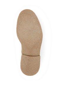 Semelle de chaussure en caoutchouc marron texturé avec une forme arrondie, comportant une zone centrale lisse et une couture visible au talon.