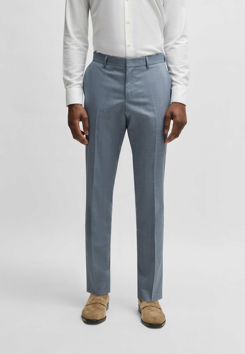 Light blue tailored trousers with a textured weave, flat front, and pressed creases. Paired with tan shoes and a white button-up shirt.