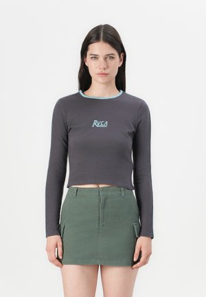 Long-sleeved, dark gray crop top with a light blue neckline and RVCA logo. Paired with a green mini skirt featuring cargo pockets.
