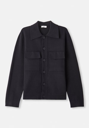 Cárdigan de punto en navy con cuello, mangas largas, dos bolsillos en el pecho y cierre de botones en la parte frontal. Textura suave con un ajuste entallado.