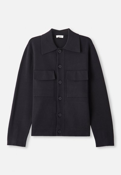 Marineblå strikkegenser med krage, lange ermer, to brystlommer og knappeåpning foran. Glatt tekstur med en skreddersydd passform.