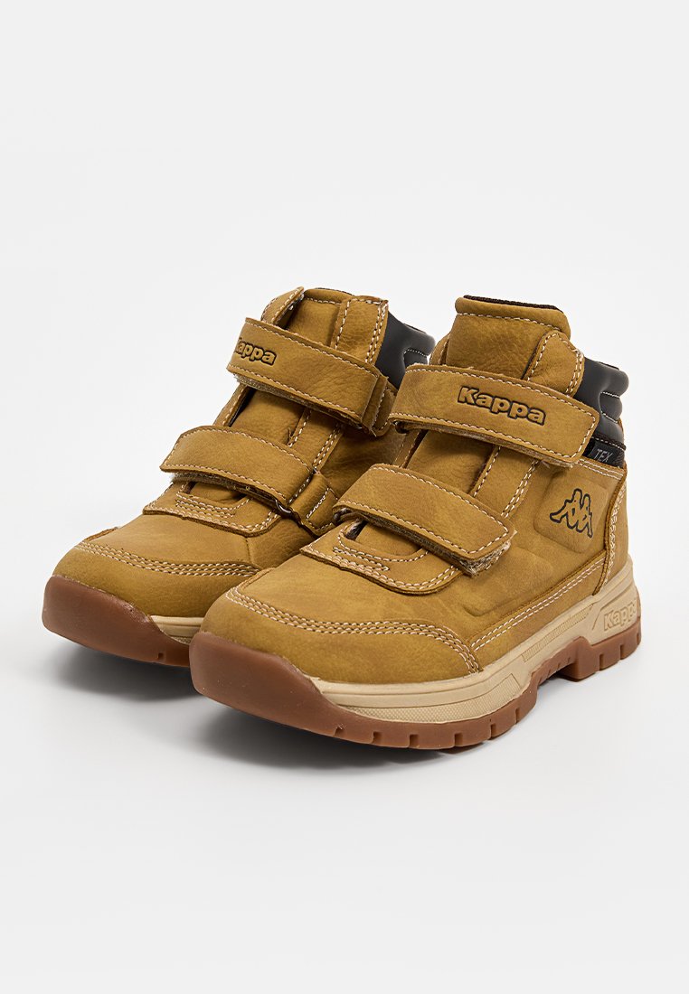 Braune Wildleder-Mid-Top-Stiefel mit doppelten Velcro-Riemen, schwarzen Akzenten und einer Gummisohle. Merkmale sind Kontrastnähte und ein gepolsterter Schaft.