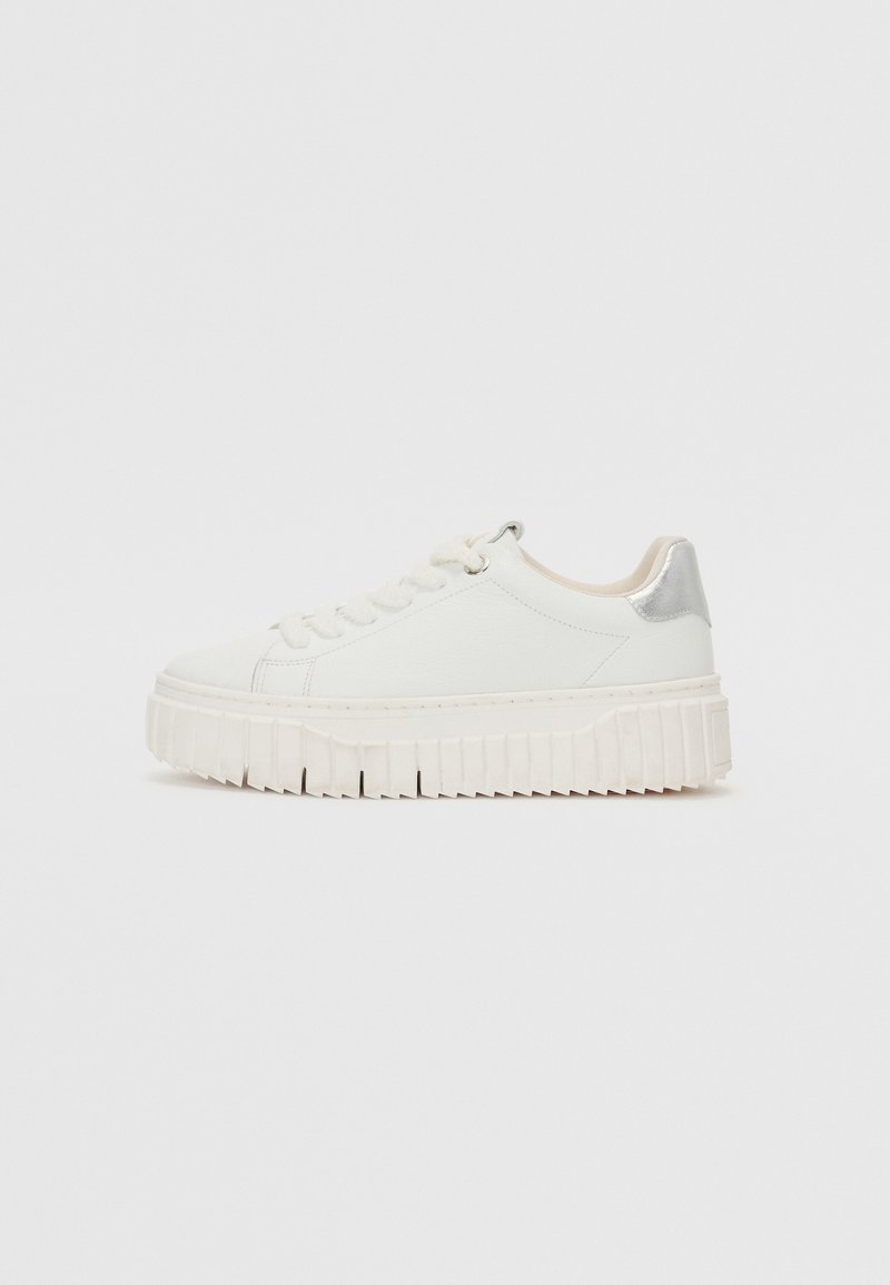 Sneaker in pelle bianca con punta arrotondata, suola spessa e rigata, e un accento argento sul tallone. Presenta un design con lacci e una texture liscia.
