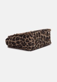 Bolso de tela con estampado de leopardo, de forma rectangular, textura suave, bordes con flecos y detalles metálicos en la parte inferior para ofrecer estabilidad.