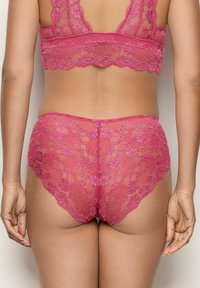 Bralette en dentelle rose et culotte taille haute assortie, ornés de motifs floraux, d'un design à bords festonnés et d'une texture transparente.