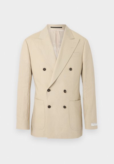 Μπεζ δίπλο σακάκι ανδρών με έξι σκοτεινά κουμπιά, πέτο γιακά, δύο μπροστινές πλαϊνές τσέπες και μια μικρή ετικέτα στο μανίκι.