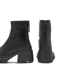 Černé kožené kotníkové boty s masivním podpatkem, bočním zipovým detailem, hladkým povrchem a minimalistickým designem.