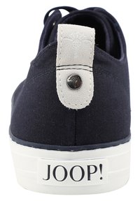 Bottines bleu marine avec semelle blanche, tirant en suède beige avec un logo brodé et un bouton en métal, et une marque "JOOP!" sur la semelle.