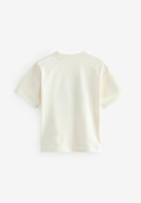 Camiseta de manga corta color crema hecha de algodón con cuello redondo, que presenta una textura suave y sin patrones ni acentos visibles.