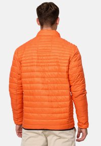 Orange pufferjakke med en quiltet design, der har vandret syninger og en høj krave. Letvægts, strømlinet silhuet.