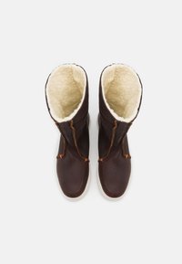 Brown leather winter boots with white shearling lining, a tall design, orange accents, and a white rubber sole. Top view.