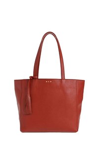 Sac fourre-tout en cuir rouge avec doubles poignées et un pendentif décoratif suspendu sur un côté, arborant une texture granitée et de subtils clous dorés.