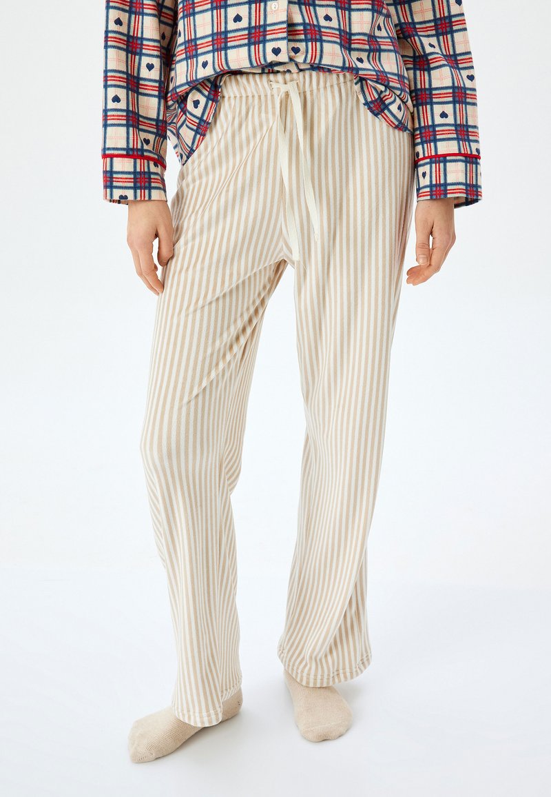 Ljusbeige randiga pyjamasbyxor med elastisk midja och snörning. Mjuk tyg, vida ben och sidfickor.