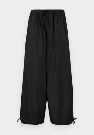 Schwarze Weitbein-Hose mit elastischem Bund, Knopfleiste und verstellbaren Kordeln am Saum, flach auf weißem Hintergrund präsentiert.