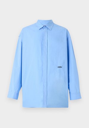 Camicia a maniche lunghe azzurro chiaro in cotone con colletto alla francese, caratterizzata da un logo nero sul lato sinistro. Tessuto morbido.
