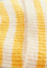 Tissu rayé en jaune et blanc, présentant une texture douce et moelleuse avec des rayures larges alternées et un léger éclat.