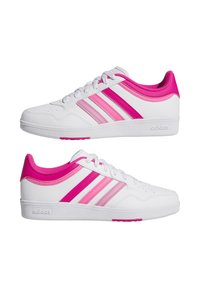 Vitaidrottsskor i vitt med tre rosa ränder, slätt syntetiskt material, rund tå, snörningsdesign, mönstrad sula och vadderad krage.