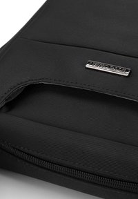 Custodia per laptop nera in tessuto con superficie strutturata, dotata di una cerniera metallica argentata e di una placca rettangolare con logo cucita sul davanti.