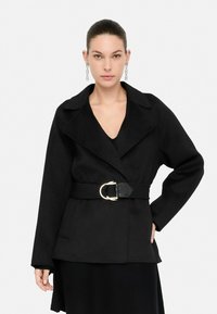 Abrigo negro con cinturón, que presenta un amplio cuello, una hebilla de cinturón texturizada y una silueta ajustada. Tela suave con un diseño estructurado.