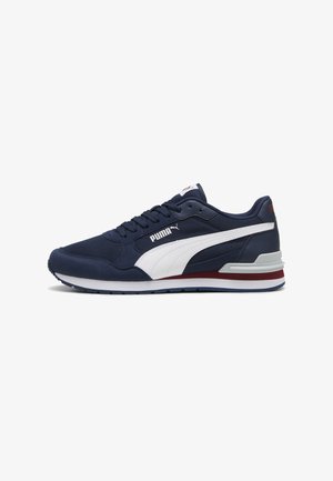 Baskets Puma bleu marine avec bande latérale blanche, accents blancs et rouges sur la semelle, design à lacets et logo de la marque sur le côté et la languette.