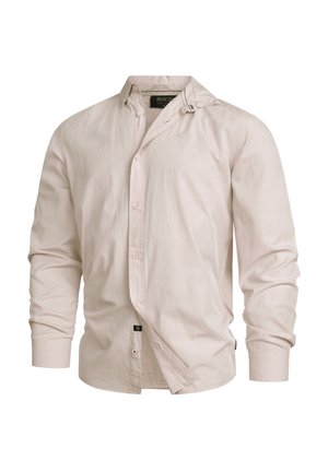 Light pink long-sleeve button-up shirt with a collar, made from smooth fabric. Features a side tag and slightly wrinkled texture.