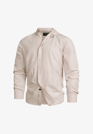 Ljusrosa långärmad skjorta med knappar och krage, tillverkad av mjukt tyg. Har en sidetikett och något skrynklig textur.