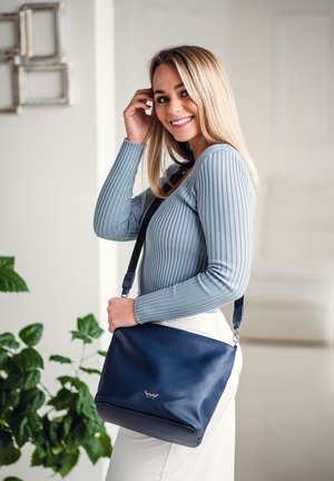 Navy leather crossbody bag with a smooth texture and silver hardware. Features a zip closure and a detachable strap for convenience.