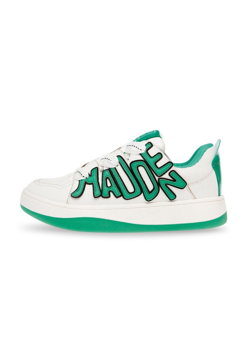 Witte sneakers met een groene rubberen zool, voorzien van een opvallend zwart letterontwerp aan de zijkant. Het materiaal lijkt glad, met gestructureerde accenten.
