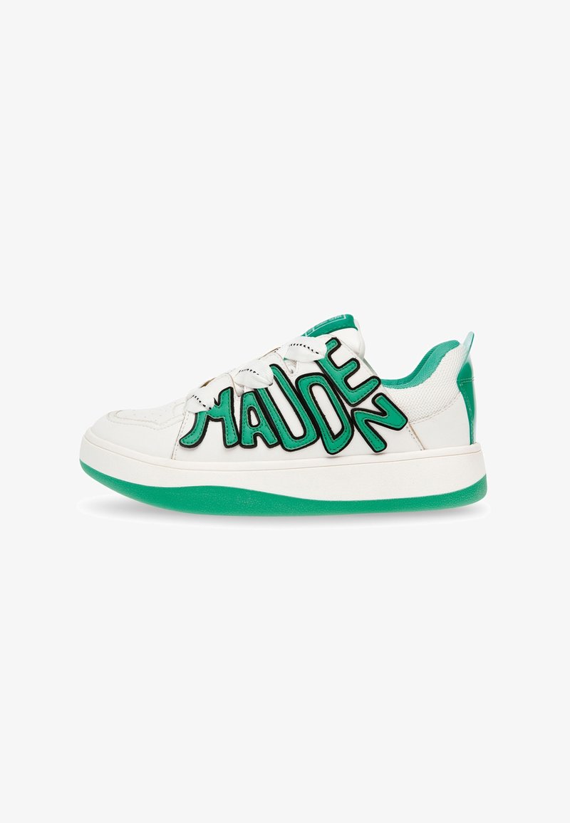 Zapatillas blancas con suela de goma verde, que presentan un diseño audaz de letras negras en el costado. El material parece suave, con acentos texturizados.