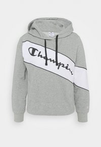 Felpa con cappuccio grigia con pannello diagonale bianco che presenta scritto in nero "Champion"; coulisse regolabile; materiale tessile morbido.