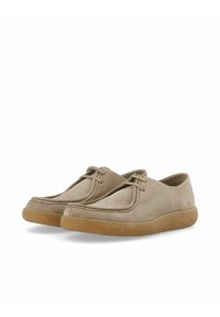 Zapatos de ante en un tono beige claro con puntera redondeada, con acentos de costura y una suela de goma flexible. Diseño de perfil bajo, sin herrajes visibles.