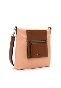 Bolso de hombro en tonos beige y durazno, fabricado con material sintético, con un bolsillo frontal con cremallera y costuras en contraste. Incluye una correa ajustable y detalle del logo.