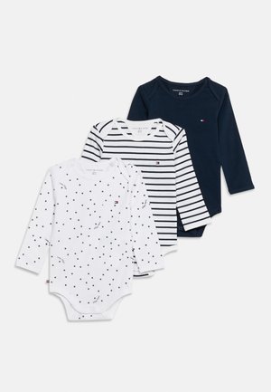 Drei Babybodys mit langen Ärmeln in Weiß mit schwarzen Sternen, Weiß mit schwarzen Streifen und einfarbig Marineblau, überlappend auf weißem Hintergrund angeordnet.