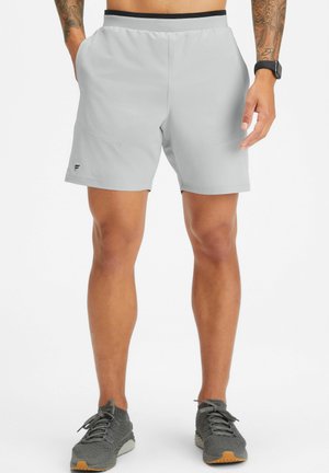 Shorts de sport gris clair avec une ceinture élastique, poches latérales et petit logo. Fabriqués en matériau évacuant l'humidité, offrant une texture lisse.