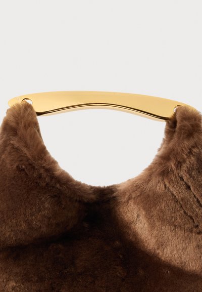 Pruunist kunstkarusnahk käekott kuldmetallist käepideme ja ümarate kujundusdetailidega. Disain rõhutab luksust ja mugavust pehme tekstuuri kaudu.