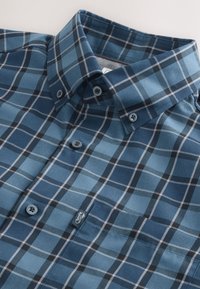 Blau kariertes Hemd mit Knöpfen und einem strukturierten Kragen, das eine Mischung aus hell- und dunkelblauen Quadraten, schwarzen Akzenten und einem Logotag zeigt.