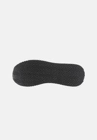 Musta kenkäpuolen pohja, jossa on teksturoitu kalanruotokuvio. Ominaisuuksiin kuuluu pyöreä kärki ja kaarevat reunat, jotka tarjoavat ergonomisen istuvuuden. Kestävä kumimateriaali.