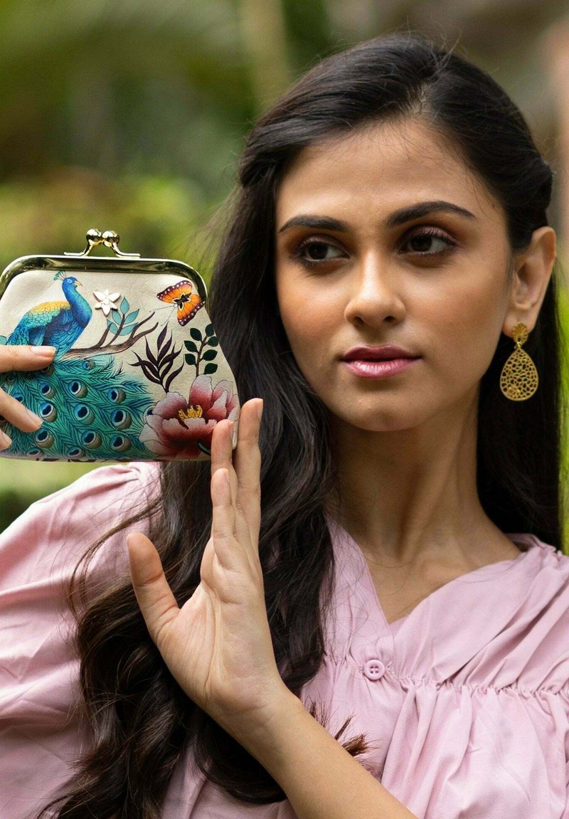 Kleurrijke clutch met pauwenmotief en bloemenaccenten, gouden metalen frame en sluiting. Gladde textuur met gedetailleerde illustraties.