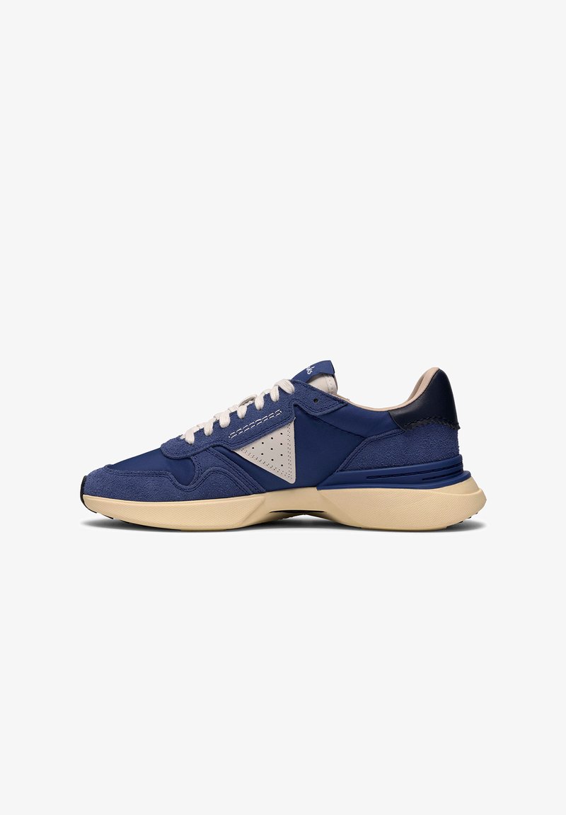 Niedrig geschnittener Sneaker in Marineblau mit beiger Sohle und weißen Schnürsenkeln, mit Wildleder und perforiertem dreieckigem seitlichem Detail.