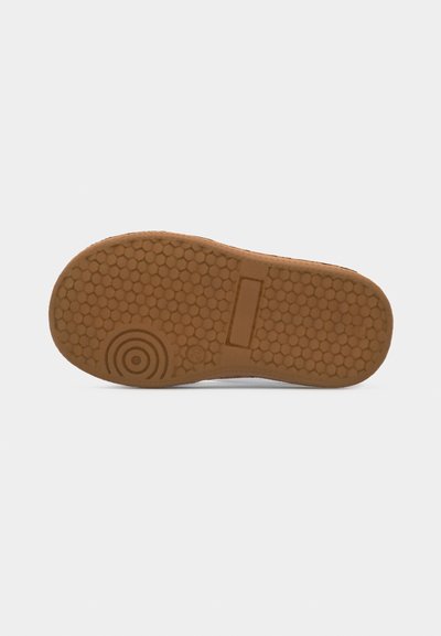 Καφέ λάστιχο σόλας παπουτσιού με εξαγωνικά και κυκλικά μοτίβα πέλματος, εμφανιζόμενο από κάτω σε απλό φωτεινό φόντο.