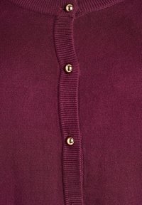 Adīta džemperis tumši violetā krāsā, ar priekšējo pogu aizdari, zelta krāsas pogām un ribotiem akcentiem ap kakla daļu un pogu rinda.