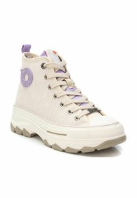 Zapatilla alta con parte superior de lona beige, acentos morados y suela de goma texturizada con un patrón de zigzag. Herrajes plateados en los cordones.