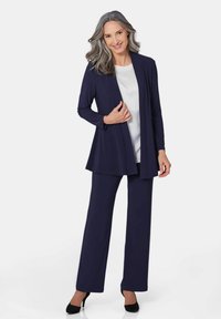 Navy-blaues Zweiteiliges Outfit mit einer offenen, langärmligen Strickjacke und passenden weit geschnittenen Hosen, kombiniert mit einem weißen Oberteil mit verzierten Akzenten.