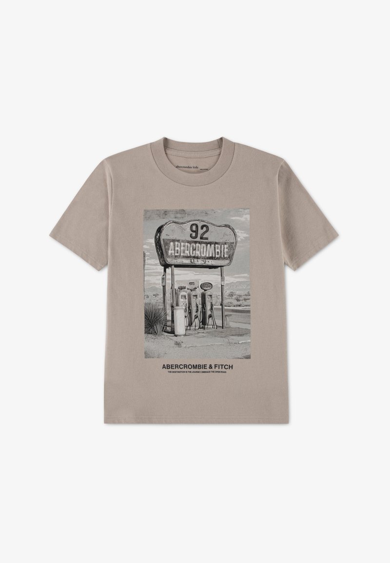 Hele beežist t-särk, millel on autorööpuliku bensiinijaama must-valge graafika ning allosas tekstid "Abercrombie" ja "Fitch". Lühikesed varrukad.